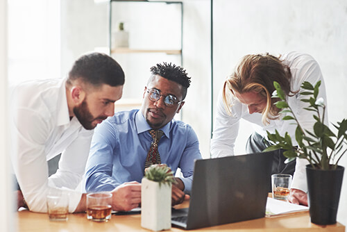 Three Men Using a Laptop.